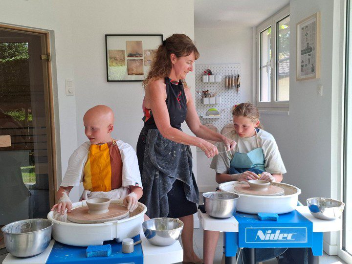 2 kinderen in een workshop draaien op de draaischijf bij Voets Ceramics